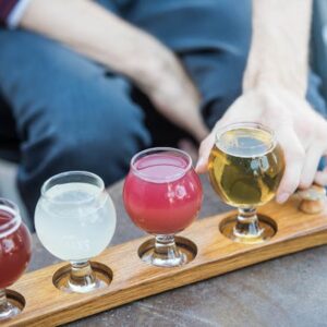 Iemand pakt een glas uit een rij glazen op een blad. (Foto: Elevate, via Pexels)