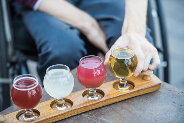 Iemand pakt een glas uit een rij glazen op een blad. (Foto: Elevate, via Pexels)