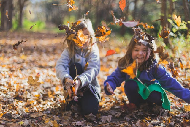 Kinderen spelen met herfstbladeren (Foto: Michael Morse, via Pexels)