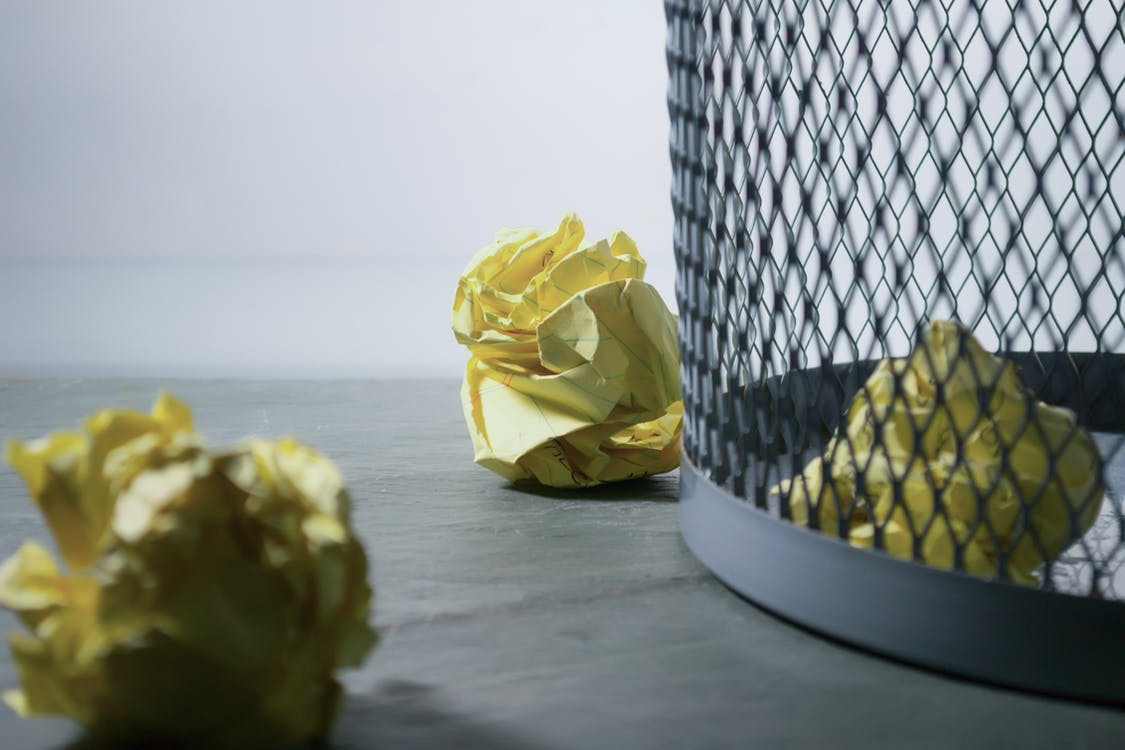 Proppen papier en een prullenbak als voorbeeld van wat je doet bij opruimen